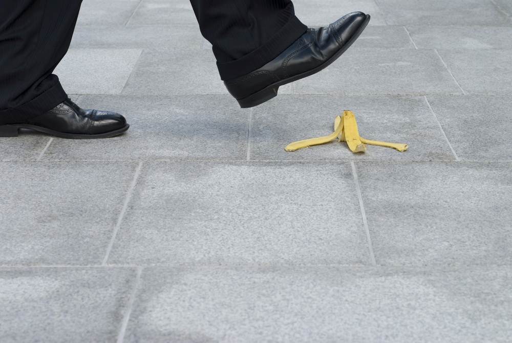 Businessman stepping on banana skin