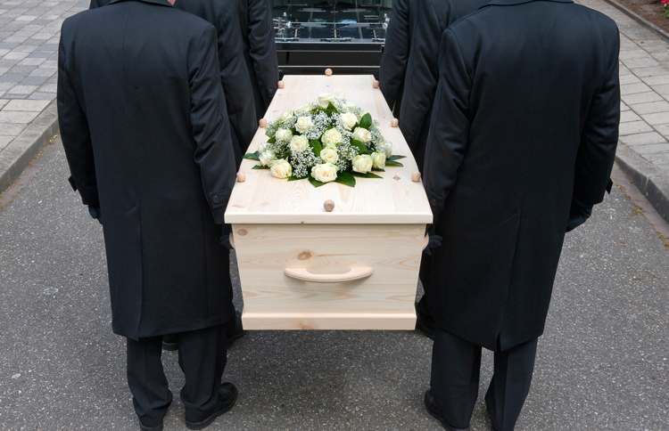 Pallbearers carrying a coffin into a car