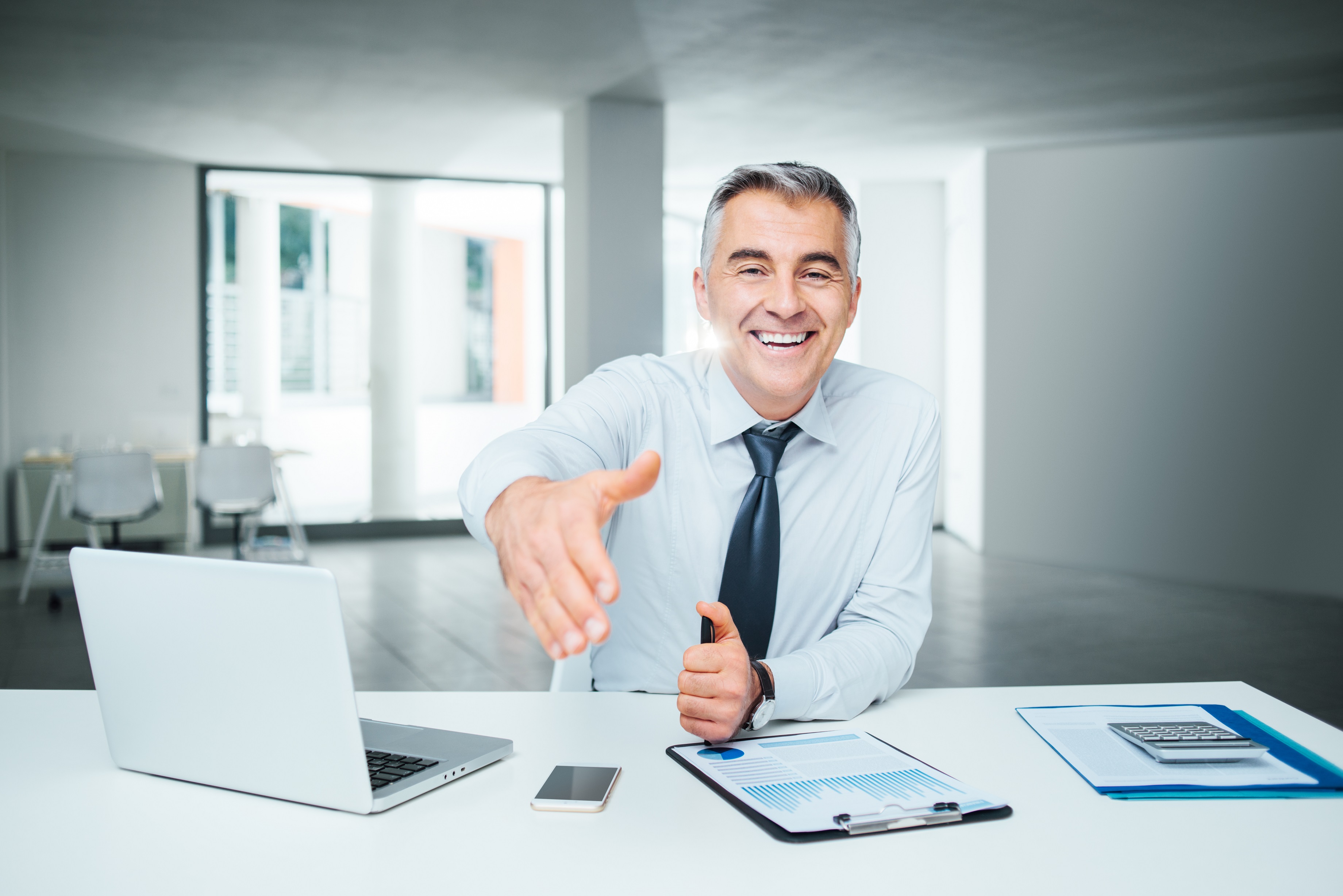 Wealth manager offering a handshake to a new client