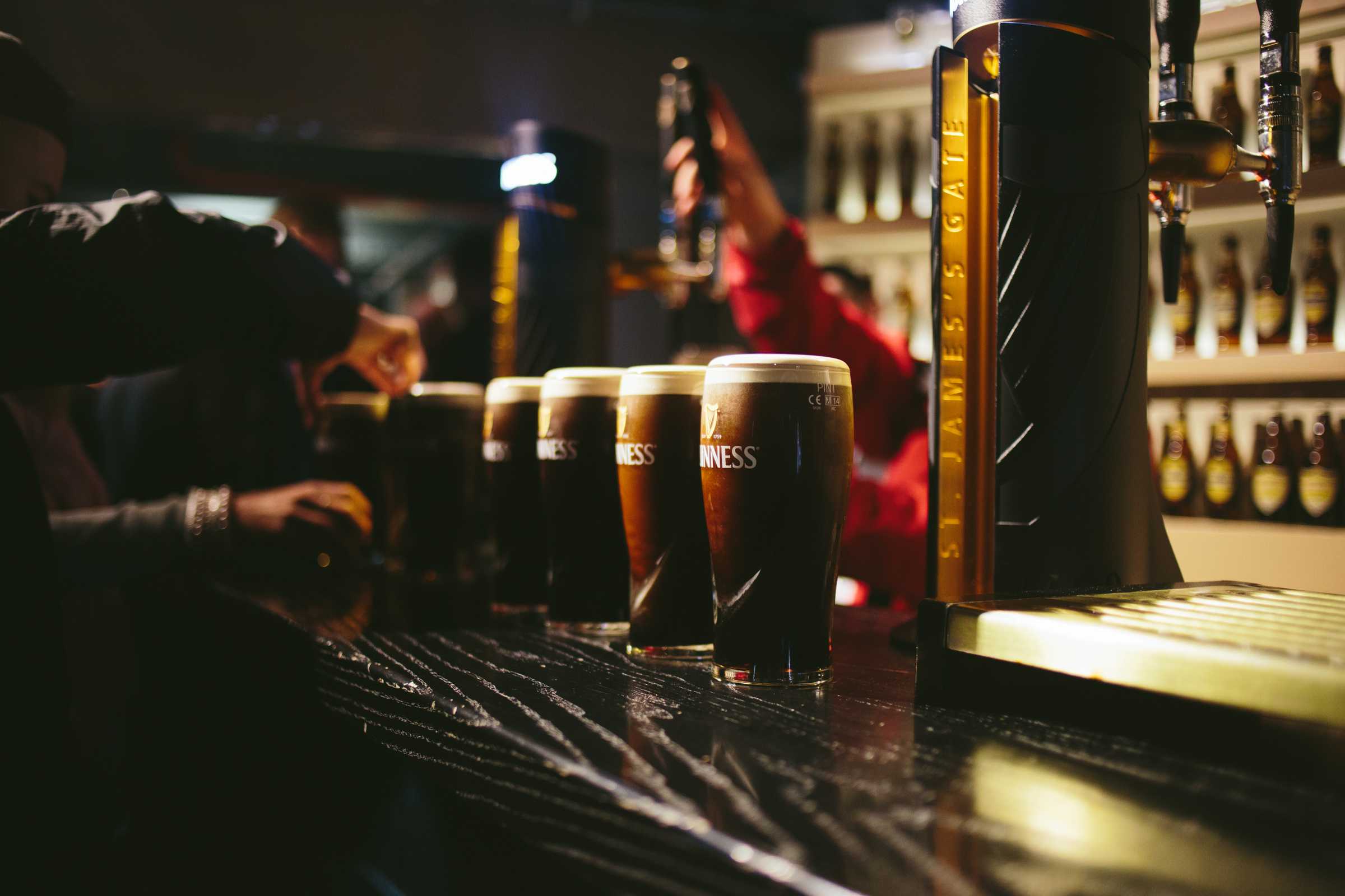 Guinness pints lined up on a bar