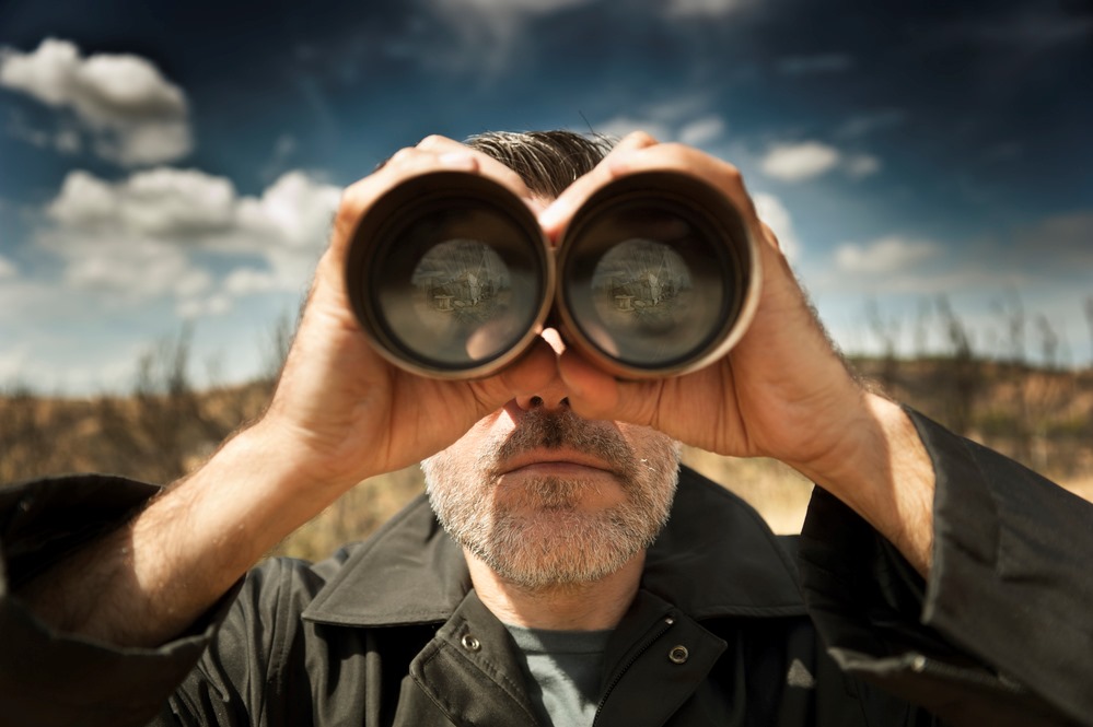 Man looking through binoculars