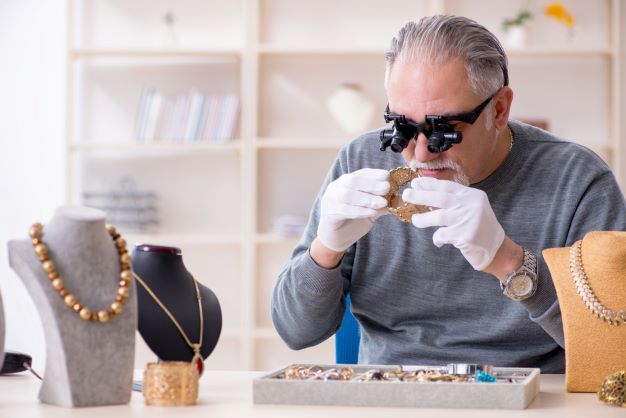 Pawnbroker examining jewellery