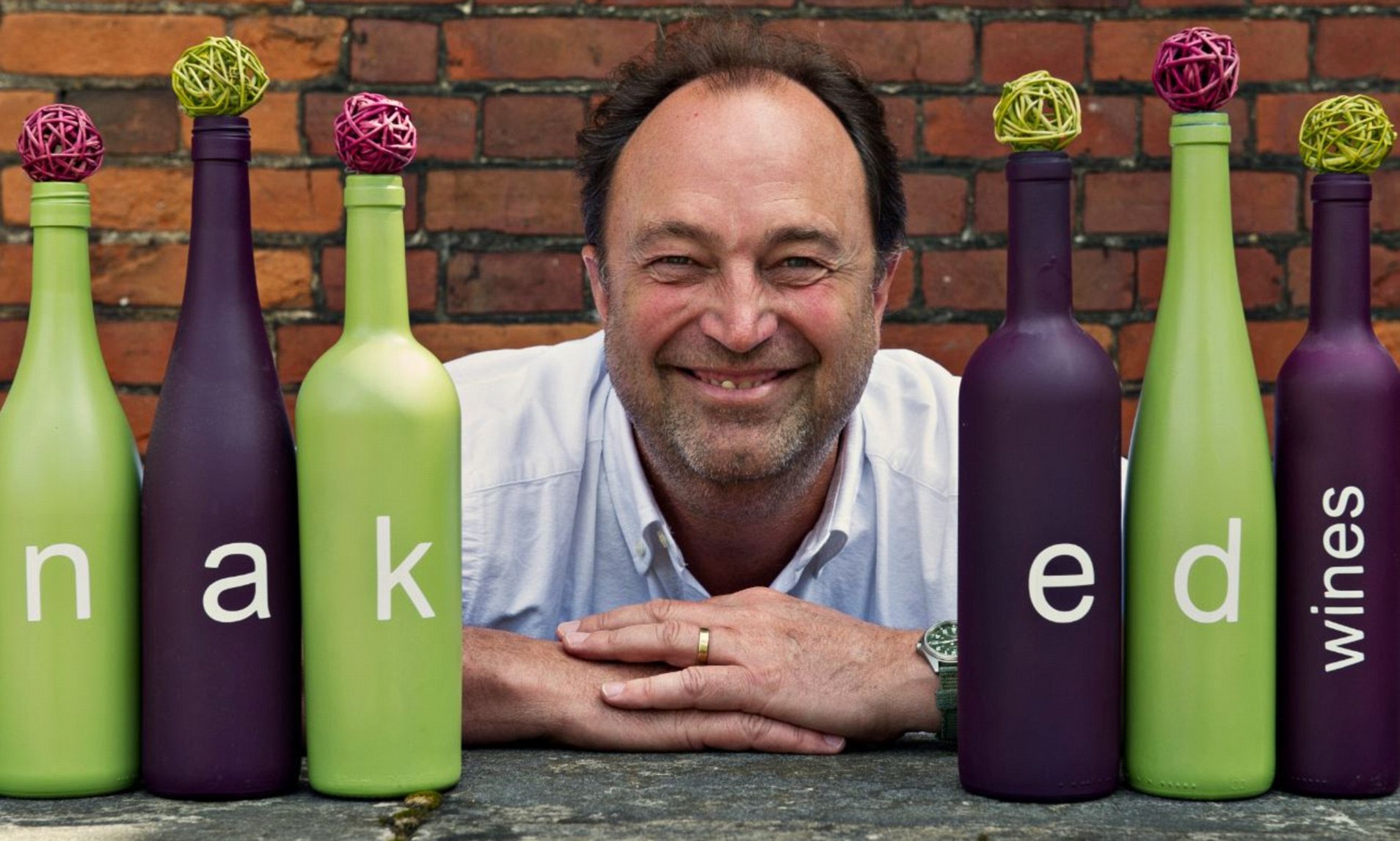 Rowan Gormley, founder of Nake Wines, in front of marketing wine bottles