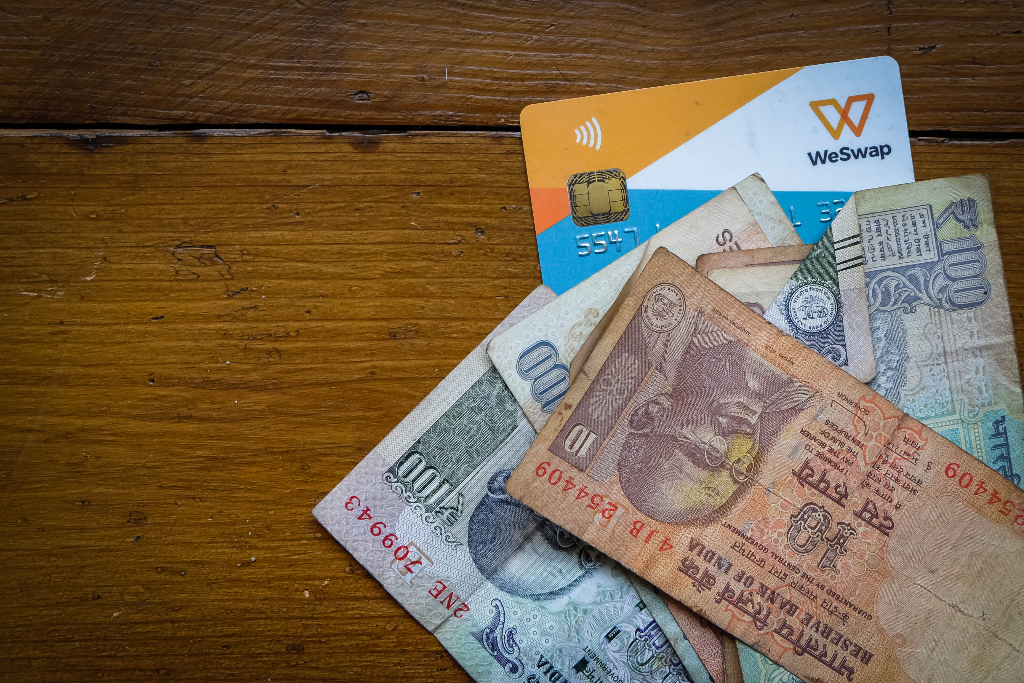 WeSwap currency card on a table with Indian Rupee notes