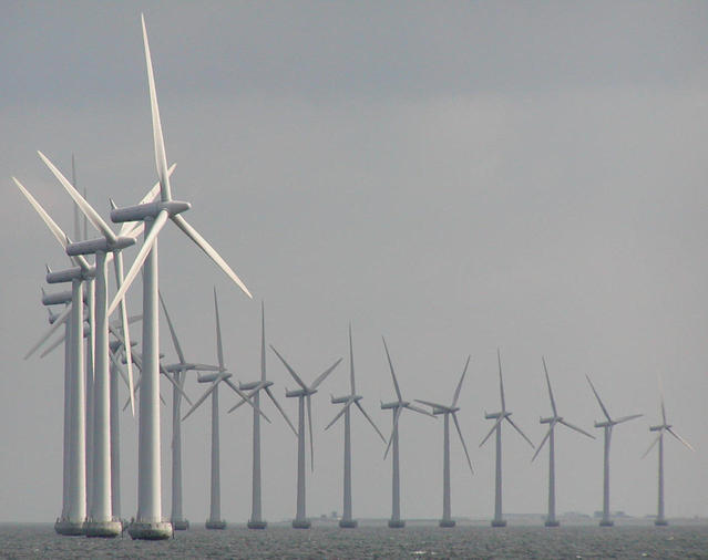 Line of windmills in a wind farm in the sea